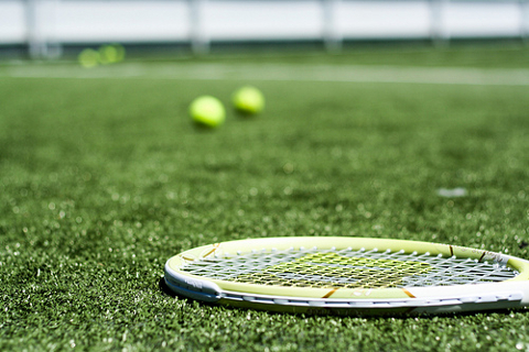 Tennis rocket and balls lying on a tennis court